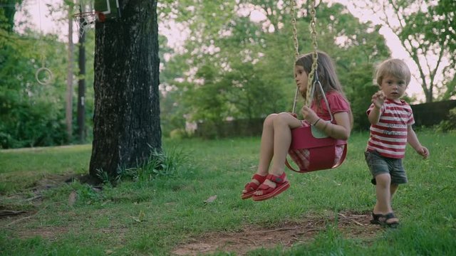 Children brother and sister in the park. Two little kids sitting in the park 4k