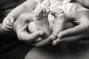 feet baby in mother hands.concept love of family.Happy Family concept.Black and white photo