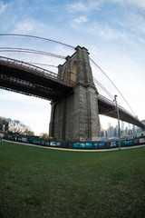 wide angle shot of New York City's Brooklyn Bridge on a Sunny Spring Day. Shot with a fisheye lens in DUMBO, Brooklyn.