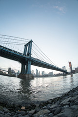 Fototapeta na wymiar An iconic shot of New York City's Manhattan Bridge - DUMBO, Brooklyn. Shot from the Cobblestone of Washington Street during the Spring of 2017 with a Fisheye Lens.