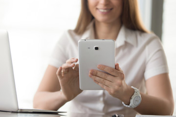 Close up image of digital tablet in womans hands. Happy businesswoman working with tablet while...