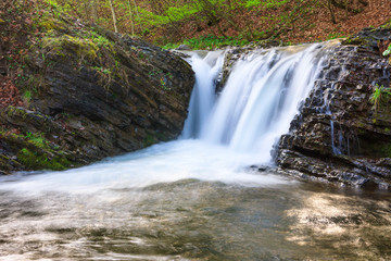 Landscape of river in mountains  and small waterfall. View of stone water rapids  and spring forest.