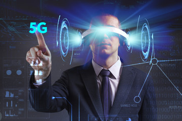Business, Technology, Internet and network concept. Young businessman working in virtual reality glasses sees the inscription: 5G