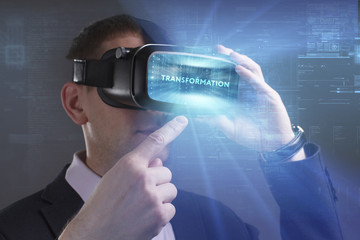 Business, Technology, Internet and network concept. Young businessman working in virtual reality glasses sees the inscription: Transformation