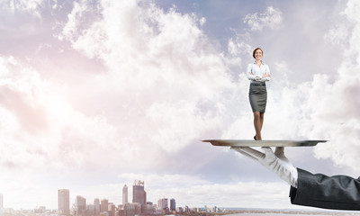 Confident elegant businesswoman presented on metal tray against cityscape background