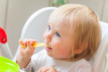 Baby eats porridge spoon mashed