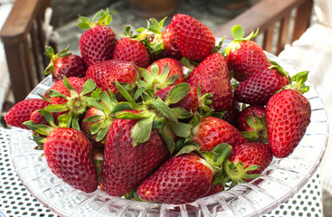 Glass bowl full of fresh strawberries closeup