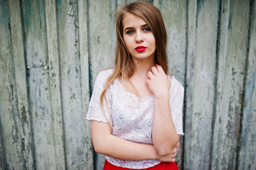 Fototapeta na wymiar Portrait of beautiful girl with red lips against wooden background, wear on red dress and white blouse.