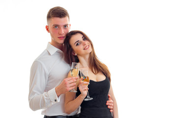 young guy standing next to a beautiful girl smiling and holding wine glasses