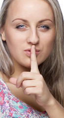 Fototapeta premium The girl shows a sign to be quieter