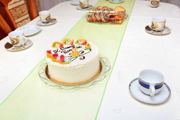 Tort urodzinowy i ciasta krojone na stole.