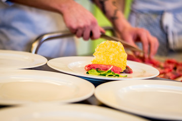 Preparing carpaccio dishes during a catering party