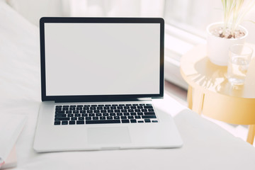 Fototapeta premium Workplace fashion blogger early in the morning, Mock up image of freelancer workplace with laptop with blank white screen