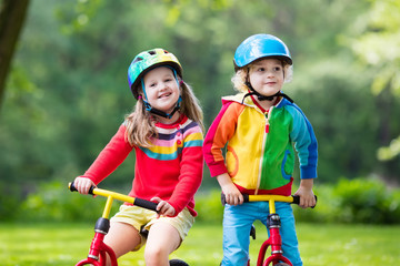 Fototapeta na wymiar Kids ride balance bike in park