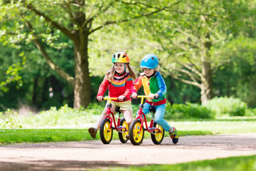 Kids ride balance bike in park