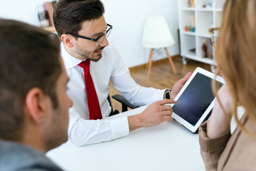 Business man explaining terms of contract to his clients in the office.