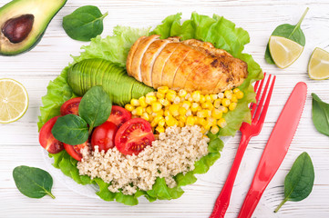 Healthy dinner with quinoa, chicken, tomatoes, avocado, spinach and lettuce leaves.  Buddha bowl. Healthy salad bowl on white background. Top view