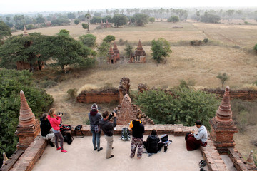 Tourists on a tepmle waiting for the sun to rise over Bagan