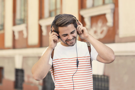 Handsome man with headphones listening music on street