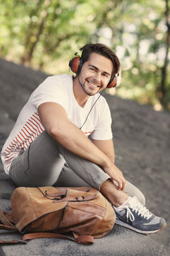 Handsome man with headphones listening music on street