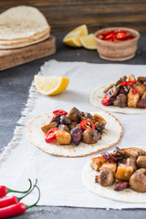 Tacos with grilled mushrooms, Spanish spicy sausage chorizo, Mexican tortillas, Cypriot cheese halloumi, hot chilly, dried oregano, slices of lime and lemon, on cloth