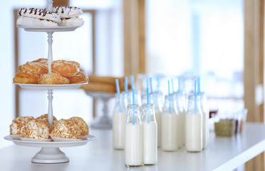 Table with bottles of milk and dessert stand