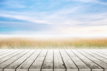 Wood table top with grass natural and blue skies background. concept party,display, county, products,natural,farm,organic.