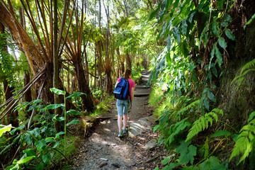Naklejka na ściany i meble Tourist hiking on Kilauea Iki trail in Volcanoes National Park in Big Island of Hawaii