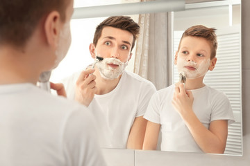 Father and son shaving in bathroom