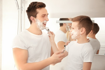 Father and son shaving in bathroom