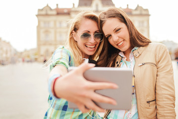 Young smiling women taking a selfie with tablet. Lifestyle, technology