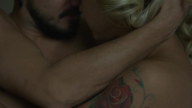 Couple with tattoos in bed.