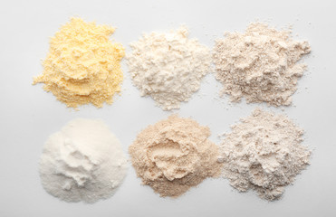 Different types of flour on white background
