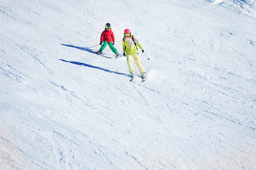 Fototapeta na wymiar Two skiers hitting the slopes at snowy mountains