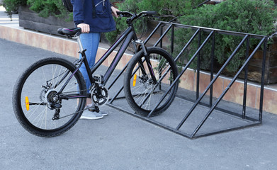 Fototapeta na wymiar Young woman parking bicycle outdoors
