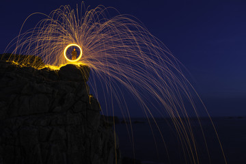 A wire wool shot on the cliffs of Sennen, Cornwall with the sparks falling into the water