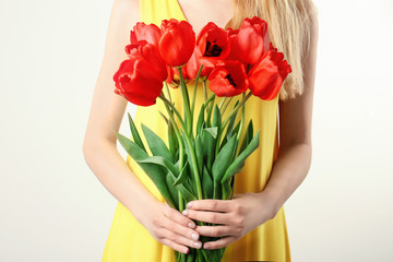 Beautiful young woman with bouquet of tulips on white background, closeup