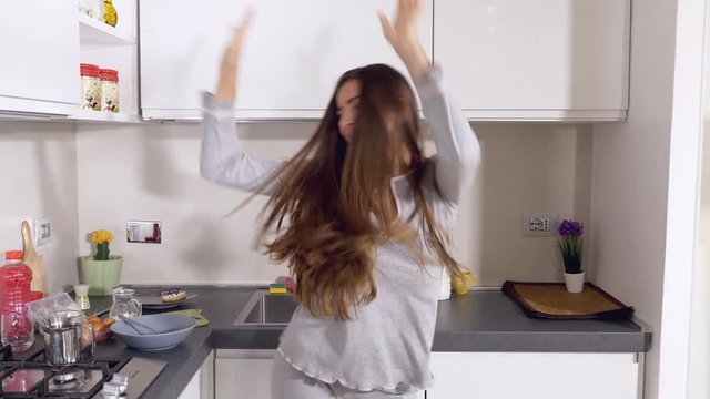 Man pushing away girlfriend from kitchen to dance like crazy