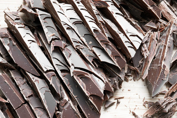 Close up of fine chocolate chopped by hand, sliced off the block with a knife.