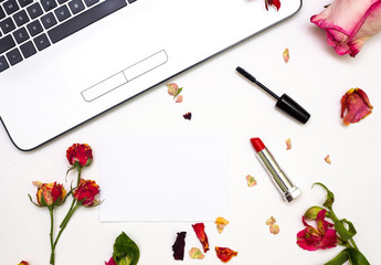 Decorative flat lay composition with cosmetics and flowers. Top view on white background