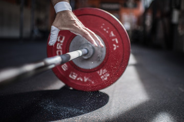 Man Weightlifter Lifts a Barbell weight In a Gym