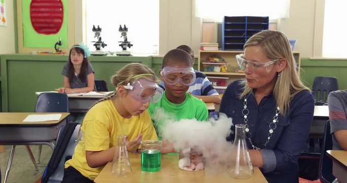 Teacher and students doing science experiment in school classroom