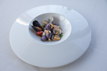 Mediterrane Küche - diverse Muscheln in weißem Teller