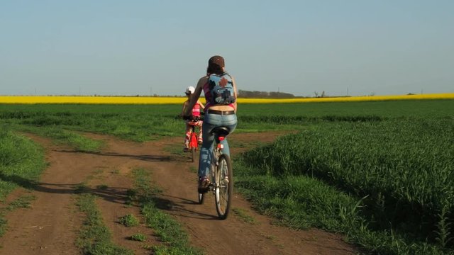 Family on bicycles. A woman with a child on a ride on bicycles. Lifestyle. Healthy lifestyle. Sport family. Countryside.