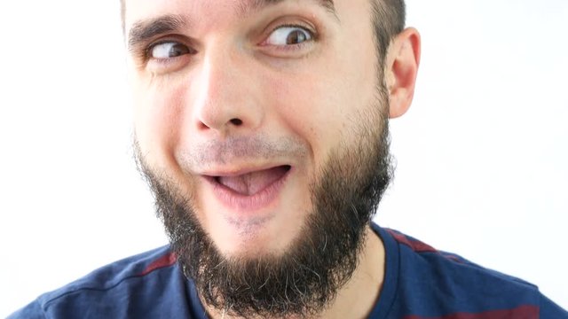 Close-up of crazy bearded man face grimacing and making funny faces, studio isolated on white background.