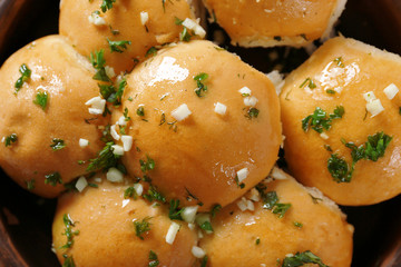 Close up view of tasty bread rolls with garlic and herbs