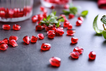 Pomegranate seeds on gray table, closeup