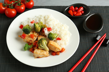 Chicken stir fry with rice and chopsticks on table