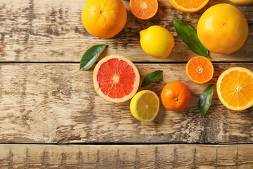 Fresh assorted citrus fruits on wooden background