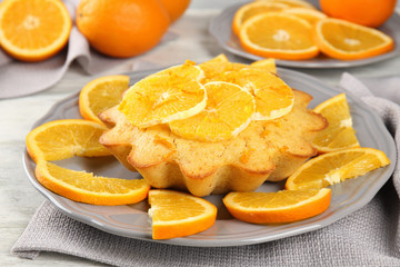 Plate with delicious citrus cake on table